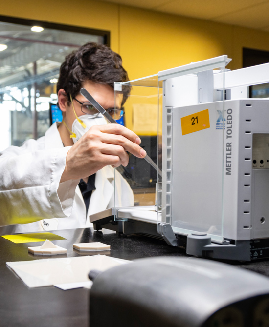 Andrew conducting a specific gravity test on PVC specimen other angle