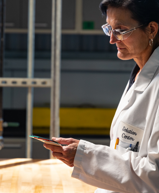 person wearing lab coat and goggles