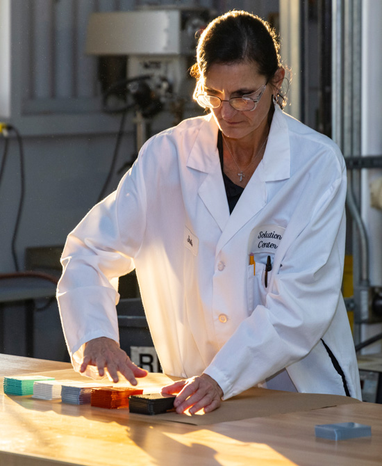 person wearing lab coat sorting colored cards