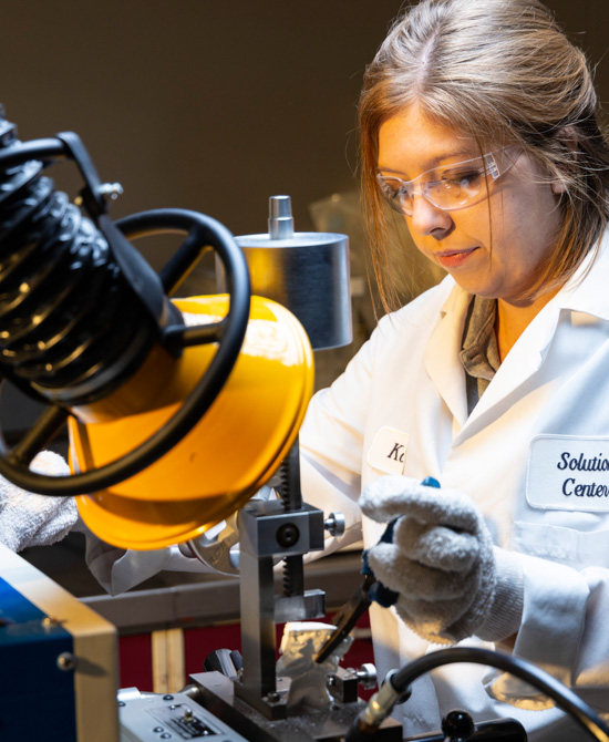 person wearing lab coat and safety goggles