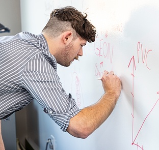 person writing on whiteboard