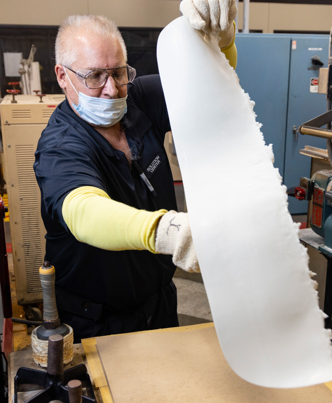 employee rolling out material on table