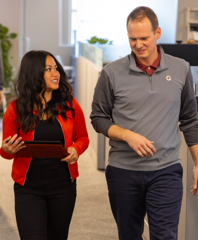 two people walking and having a conversation in an office