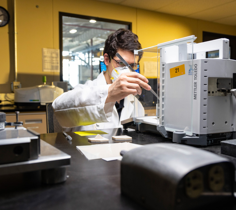 Andrew conducting a specific gravity test on PVC specimen other angle